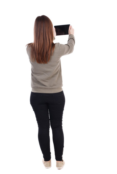 后視圖站年輕美麗的女人使用移動的臥佛寺