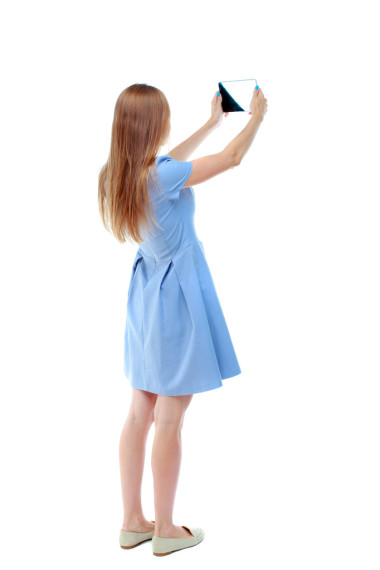 后視圖站年輕美麗的女人使用移動的臥佛寺