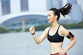 运行一个湖边的年轻亚裔女子图片