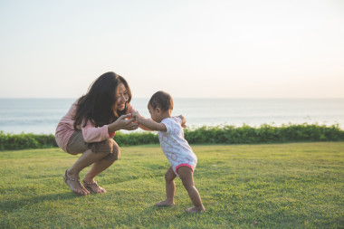 快樂(lè)寶貝使他在綠色的草地上的第一步