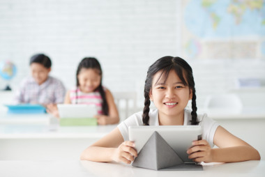 平板電腦坐在桌子旁邊的女孩
