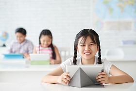 平板电脑坐在桌子旁边的女孩