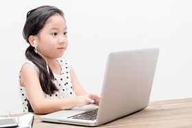 可爱的女生女孩与桌上的笔记本电脑电脑