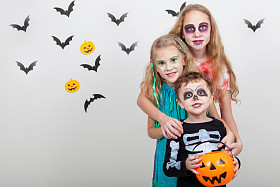 快乐的哥哥和两个姐妹在万圣节派对上