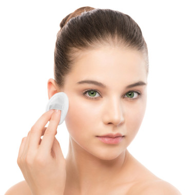 年轻女子爱着脸上的皮肤。清洗的完美新鲜皮肤使用棉垫。分离