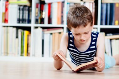 七歲的小男孩在圖書館看書