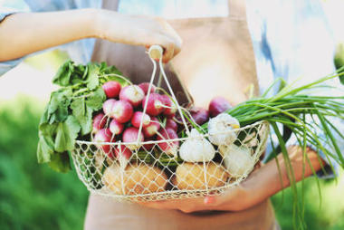 女人抱著籃子新鮮蔬菜