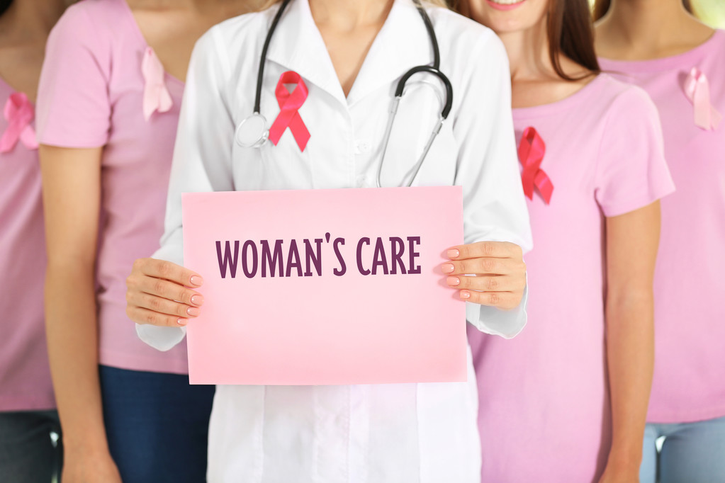 妇科概念。女医生和女孩子用粉红色的丝带 妇科概念。女医生和女孩子用粉红色的丝带