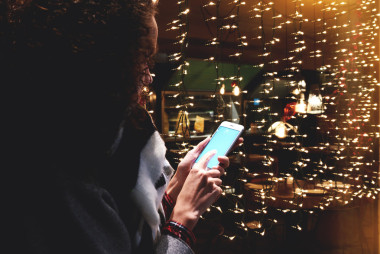 關(guān)閉的形象是一個年輕的時髦女孩抱著細(xì)胞電話與空白副本空間屏幕為您的廣告短信或促銷內(nèi)容