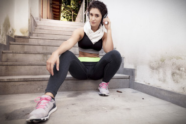 年輕女子賽跑運(yùn)動員放松從耳機(jī)聽音樂