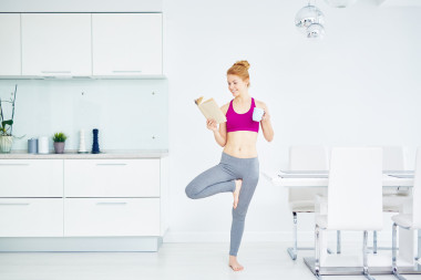 微笑在明亮的運動服，在廚房里的女人