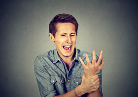 年轻人握着他疼痛的手腕扭伤疼痛