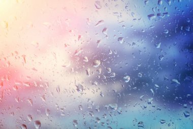 雨水滴與太陽在玻璃背景