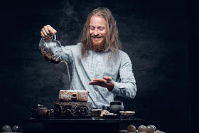 积极的胡子的男倒热茶