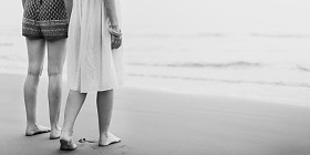 妇女赤脚走在海滩