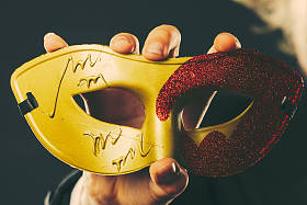 男手中握有狂欢节面具特写照片