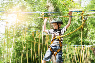 孩子們爬在冒險(xiǎn)公園。男孩喜歡攀爬繩子