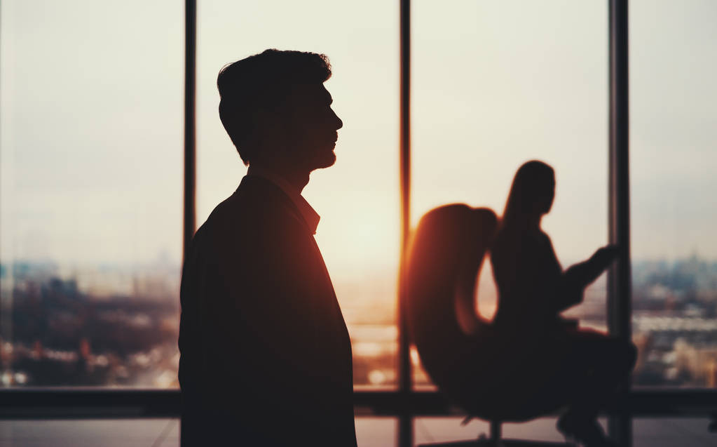 商人在办公室窗前的剪影图片 商人在办公室窗前的剪影图片