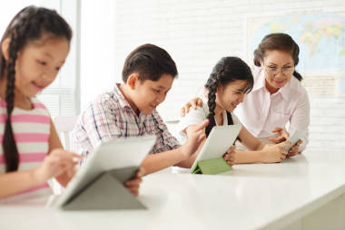 老師幫助學(xué)生對(duì)數(shù)字平板電腦