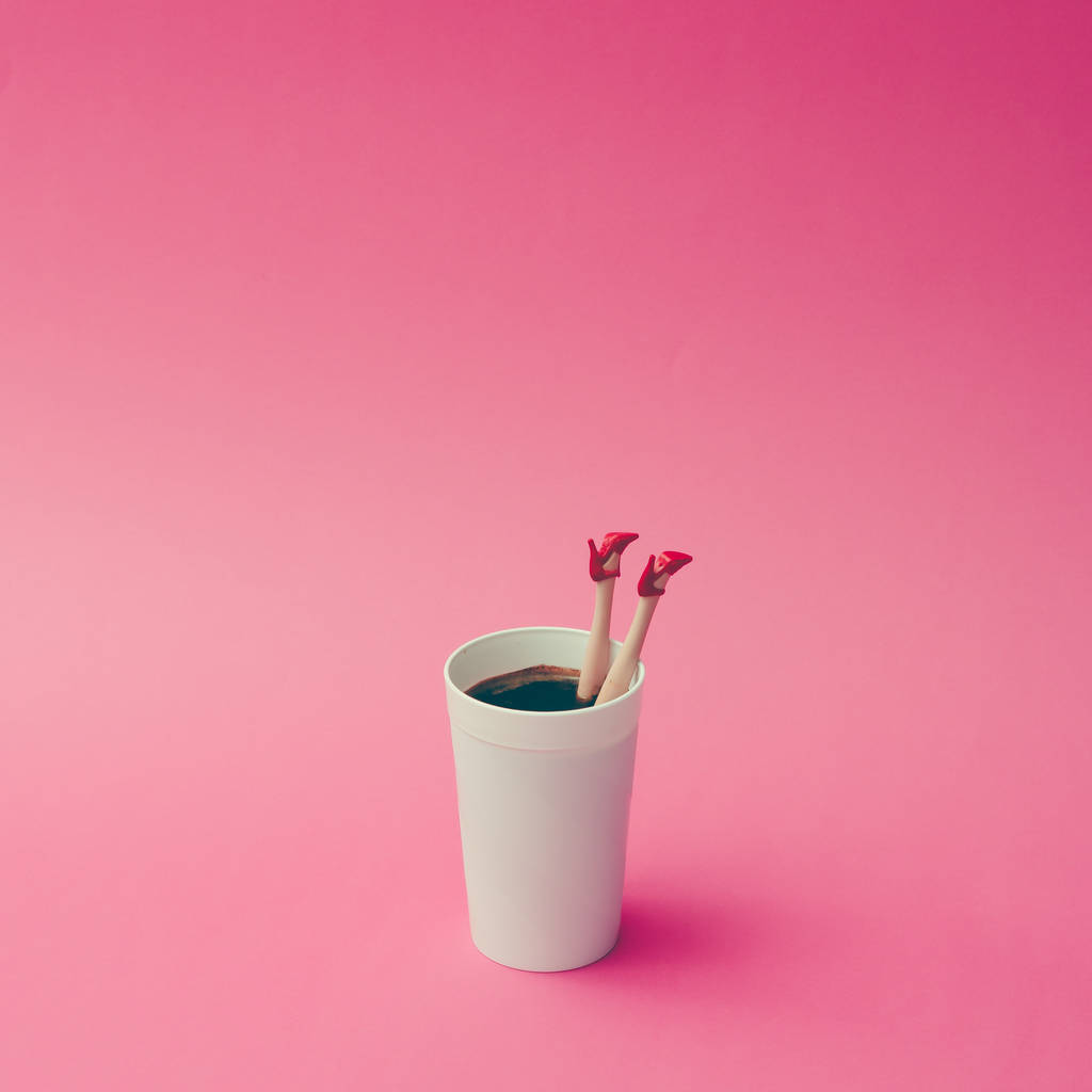 咖啡杯与女性娃娃的腿