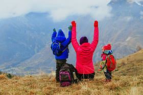 幸福的母亲和两个孩子在冬天山旅
