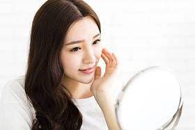 快乐的年轻女人，看镜子上图片