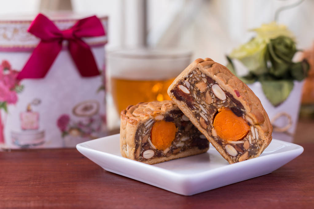 Moon cakes and tea - Traditional Chinese moon cakes on a whiteboard Moon cakes and tea - Traditional Chinese moon cakes on a whiteboard