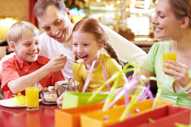 家庭坐在咖啡館和吃