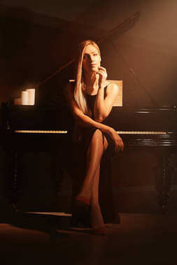 美丽的女人在钢琴照片