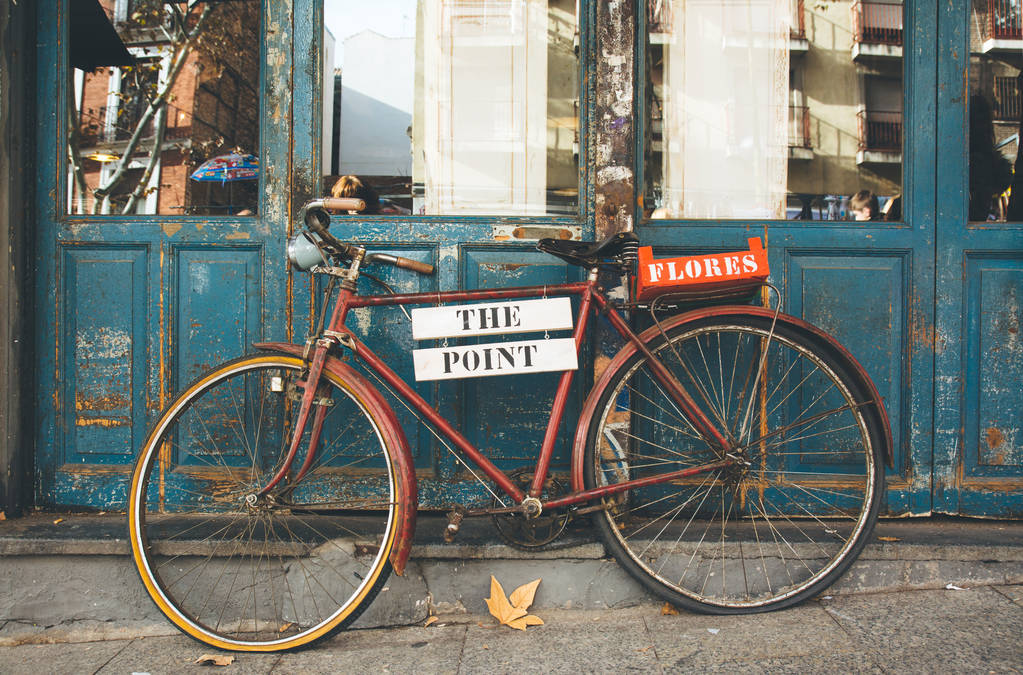 旧的蓝色门上的旧自行车