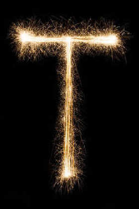 在黑色背景上的烟火字母表中的字母英文字母 T