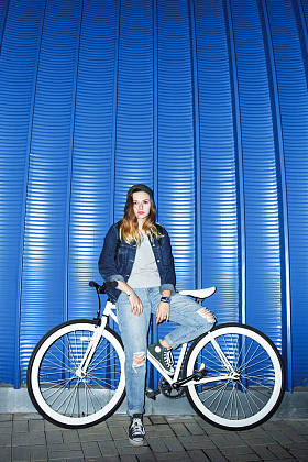 时髦女孩旁边一辆自行车合影图片