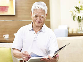 放松在家里读书的高级亚洲人图片