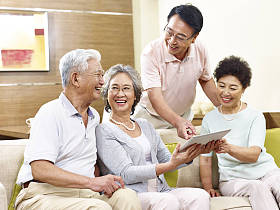 在家里使用平板电脑的两个幸福高级亚洲夫妻