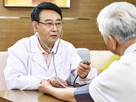 亚洲医生检查一位高龄患者血压