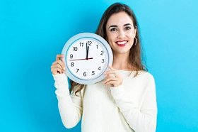 女人抱着时钟，显示近 12