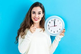 女人抱着时钟，显示近 12