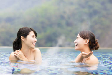 幸福的年輕女人在溫泉中休息