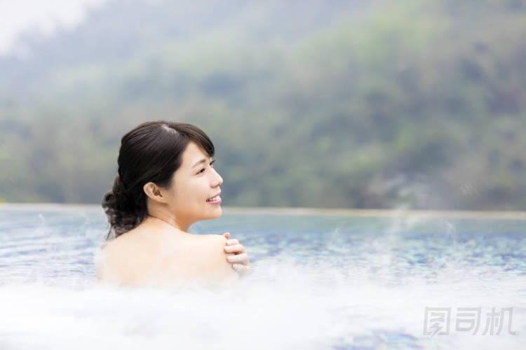 幸福的年輕女人在溫泉中休息