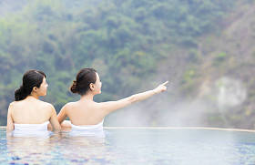 幸福的年轻女人在温泉中休息照片