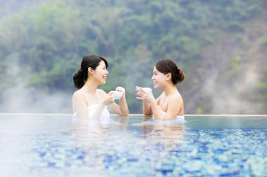 幸福的年輕女人在溫泉中休息