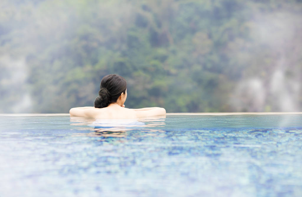 年轻女子在温泉中休息照片