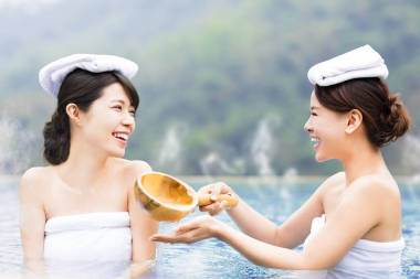 幸福的年轻女人在温泉中休息