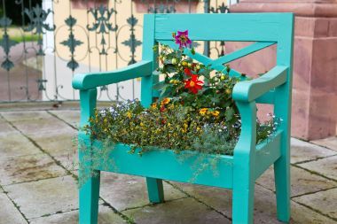 綠色的舊椅子用七彩花朵裝飾