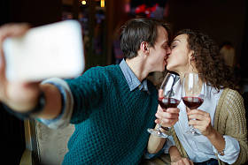 年轻男人亲吻他的妻子在餐厅图片