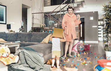 驚訝的媽媽盯著她玩的孩子照片