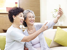 高级亚洲妇女采取自拍照图片