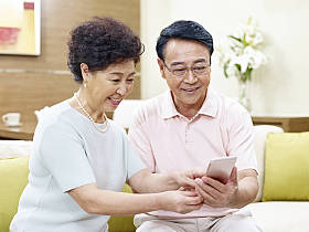 使用移动电话的高级亚洲夫妇图片