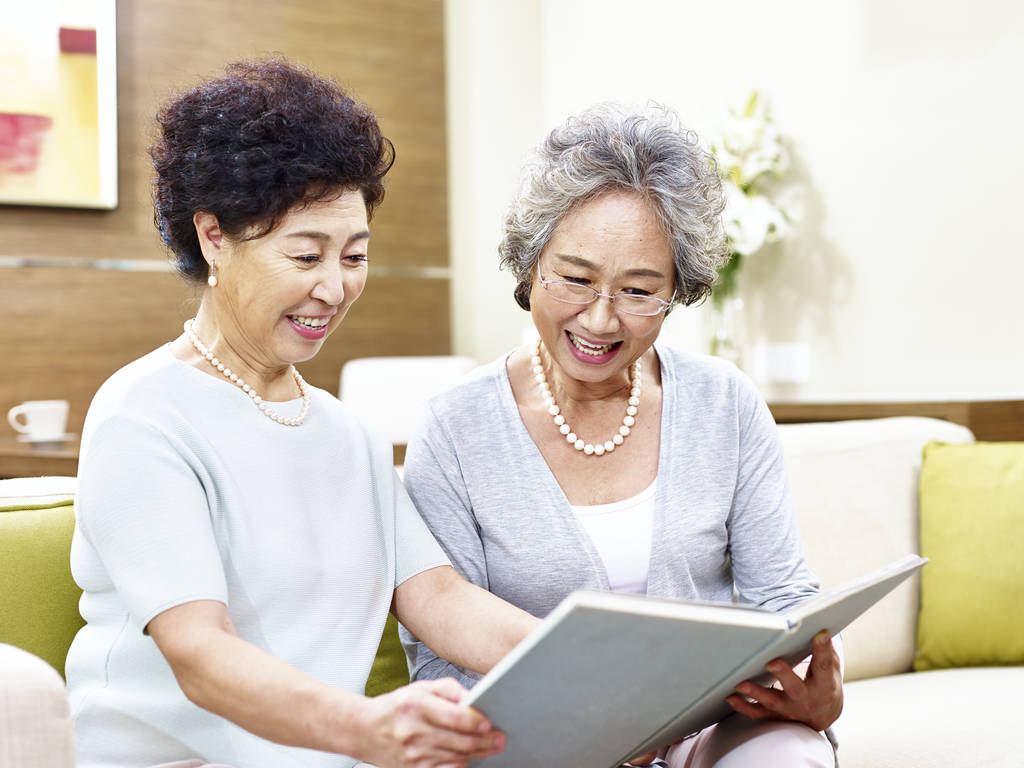 两个高级亚洲妇女一起阅读一本书