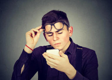 戴著眼鏡麻煩看到手機(jī)視覺問題的男人